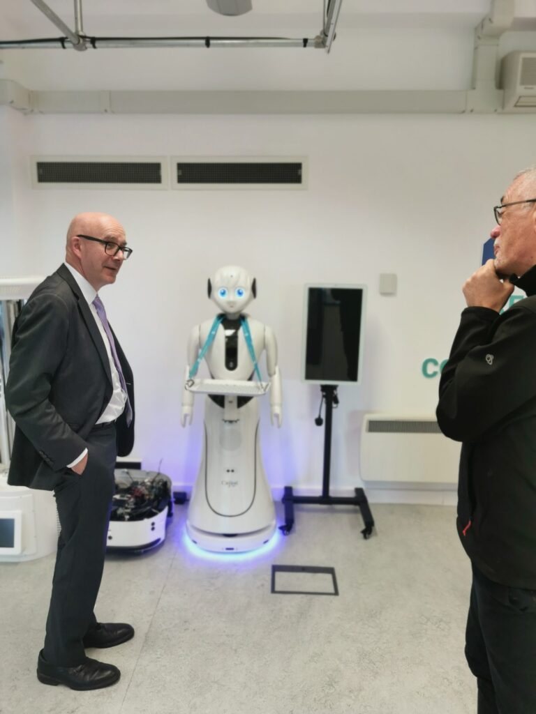 Matt Western and Steve Benford talking in front of Robin the robot